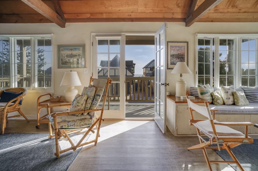 The family room with wicker chairs and French doors open to the balcony and the Pacific