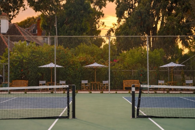The community pickleball courts at sunset, umbrellas and benches beyond
