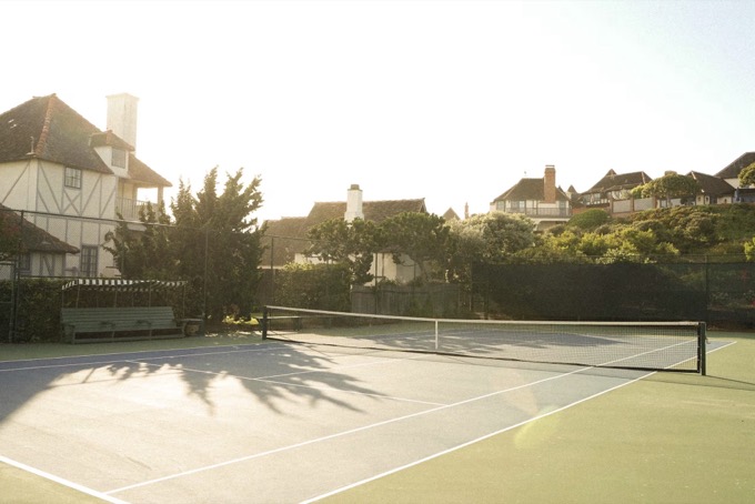 Sun-drenched tennis court inside the community